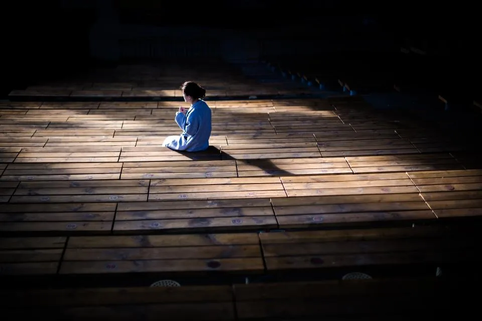 A soloist under rehearsal lighting in the main auditorium